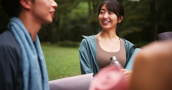 Group, laughing and water with fitness friends outdoors in park together for start of exercise routine. Funny, mat and talking with Japanese people in nature for training or workout progress