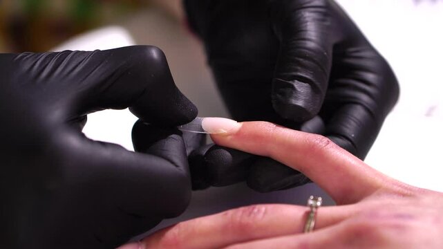 The process of nail extensions in a beauty salon. Nail coating with gel polish and top. Concept of spa body care for women.
