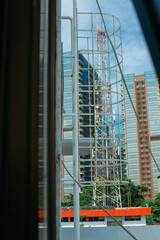 Fototapeta premium White metal fire escape attached to a wall and leading to the roof of a building.