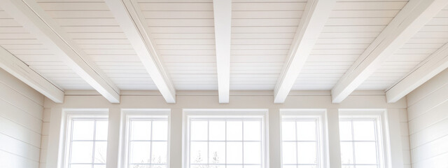 Obraz premium Modern white painted wood ceiling with matching beams and large windows. bright and airy space creates serene atmosphere, perfect for relaxation and comfort