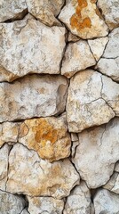 Close-up of rough, weathered stone wall with cracks and patches of orange lichen, showcasing natural textures.