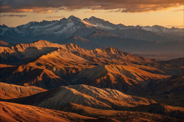 Naklejka premium Layered rocky mountains in rich brown-gold tones; sunset sky with golden-orange gradient, stones softly glowing in warm evening light