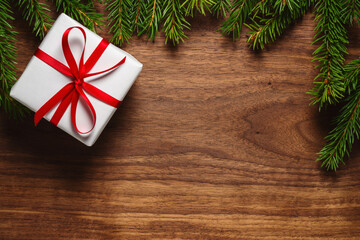 Chrismtas background top view with fir branches on wood background with present box