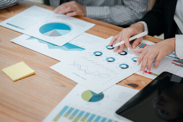 Professionals reviewing charts and graphs, focusing on financial analysis and strategic planning in a collaborative workspace.