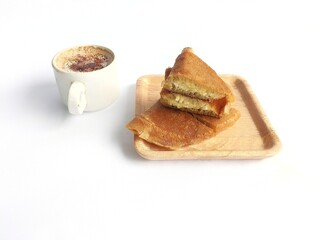 Sweet martabak served with a cup of coffee on a white background