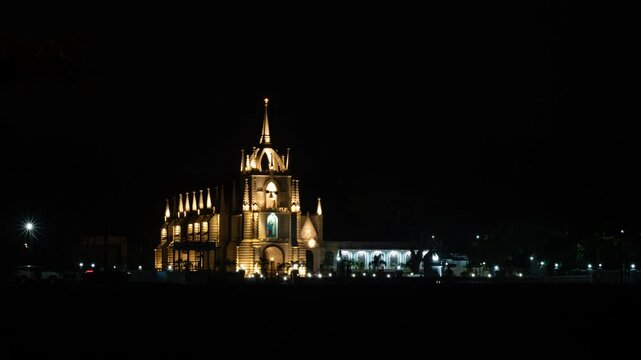4K Timelapse footage of the Neo-Gothic Mae de Deus Catholic church in Saligao Goa at dusk night with traffic light trails and illuminated church and people visiting the church