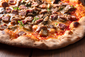 Pizza italiana condita con salsiccia fresca di maiale e funghi porcini 