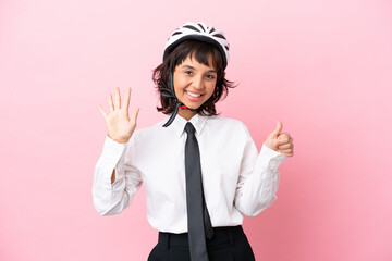 Young girl person with a bike helmet isolated on pink background counting six with fingers