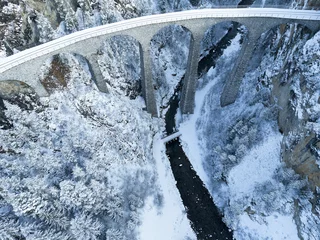 Aerial view of famous Landwasser Viaduct Unesco world heritage site in the Swiss Alps at mountain village of Filisur on a snowy autumn day. Photo taken November 22nd, 2024, Filisur, Switzerland.