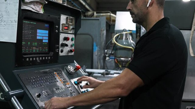 Engineer operating cnc machine control panel