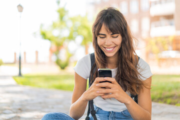 Young woman at outdoors using mobile phone