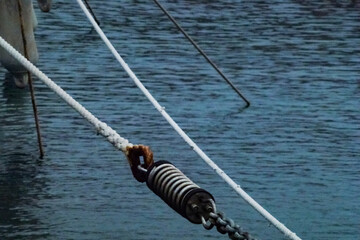 Sea mooring ropes in the marina against the water.