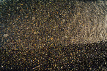 Dark pebble beach and water