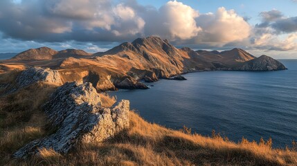 Naklejka premium Breathtaking coastal landscape with rugged mountains at sunset.