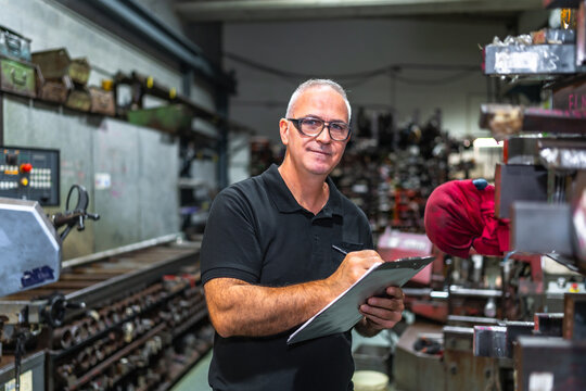 Mature worker doing inventory in a metal cnc factory