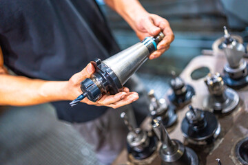 Close-up of a worker holding the head of a milling machine
