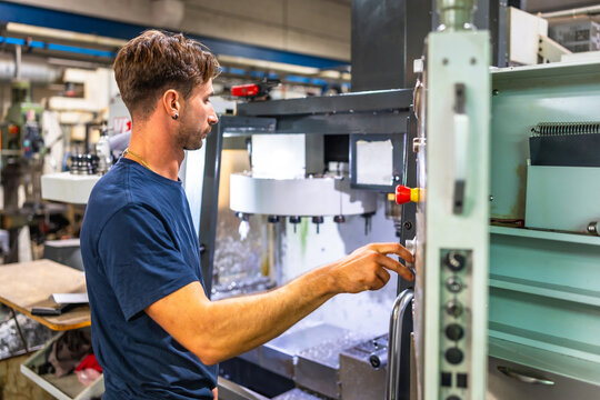 Man using mechanical machine to mold plastic parts