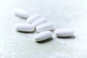 White tablets on wooden background. Soft focus. Close up. Copy space	