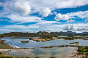Fototapeta premium A beautiful beach with a clear blue ocean and a few boats in the water
