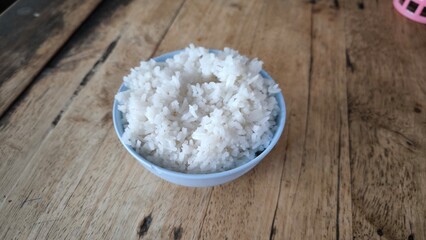 Rice in a blue bowl on a wooden table