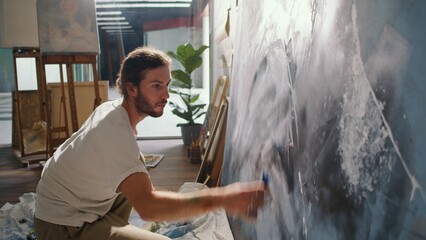 Artist Paints on the Floor in His Cozy, Bright Studio, Surrounded by His Completed Works. The Light-Filled, Inspiring Environment Encourages Him to Create New, Unique Pieces of Art in a Relaxing Space