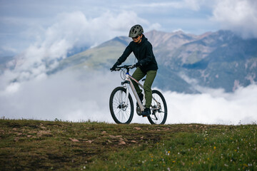 Fototapeta premium Asian woman riding mountain bike on beautiful mountain top