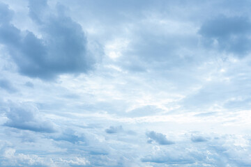 Beautiful fluffy white clouds drift across a bright blue summer sky