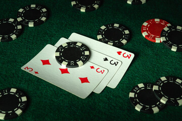 Playing cards and chips after gambling in a poker club. Three aces on the table. Successful winning...