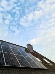 Obraz premium Solar cells on the roof of a residential building produce green electricity.