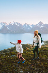 Mother and child travel hiking in mountains of Norway family adventure trip in the wild nature, healthy lifestyle activity vacations outdoor, woman and kid enjoying Lyngen Alps and fjord view