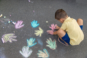 boy draws on the asphalt with chalk. Selective focus