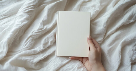 Fototapeta premium Close-up mockup of woman hands holding a blank white book. Ideal for book cover design, branding, and product display. Minimalist and cozy scene, Generative AI