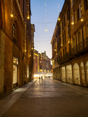 Christmas lights illuminating foggy evening street in cremona, italy