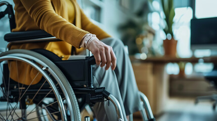 Obraz premium Woman in a wheelchair next to an office desk; hand close-up, unrecognizable person.