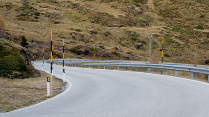 Winding mountain road with reflective markers, illustrating road safety and travel, perfect for...