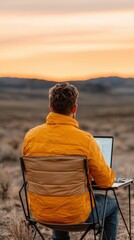 Fototapeta premium Person working remotely in nature at sunset.