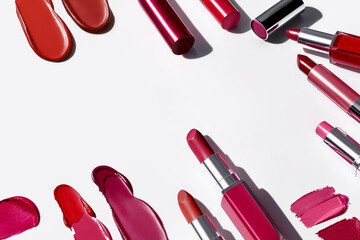 Variety of red lipsticks and swatches on a white background