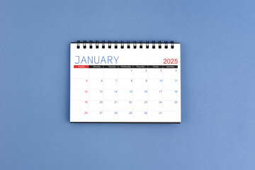 January 2025 Monthly desk calendar for 2025 year on blue background. Flat lay.