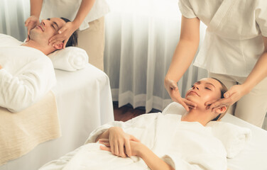 Fototapeta premium Caucasian couple enjoying relaxing anti-stress head massage and pampering facial beauty skin recreation leisure in dayspa modern light ambient at luxury resort or hotel spa salon. Quiescent