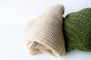 Fototapeta premium closeup of a beige and green cozy sweaters with braids rib clothing warm