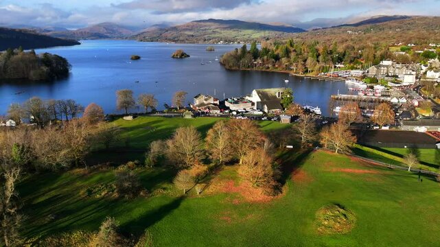 Aerial video of Windermere lake showing a fast flying fighter jet disapearing on the cloudy landscape. 