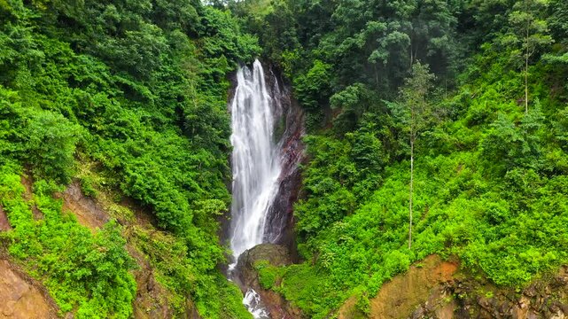 Waterfall among tropical jungle with green plants and trees. Mohini Falls. Sri Pada, Sri Lanka.