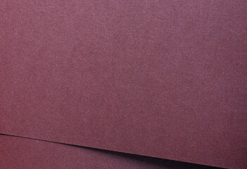 Fototapeta premium Metallic burgundy paper background with smooth, shimmering layers and subtle folds. Featuring deep, rich tones and a soft satin sheen, it combines luxury and modern elegance.