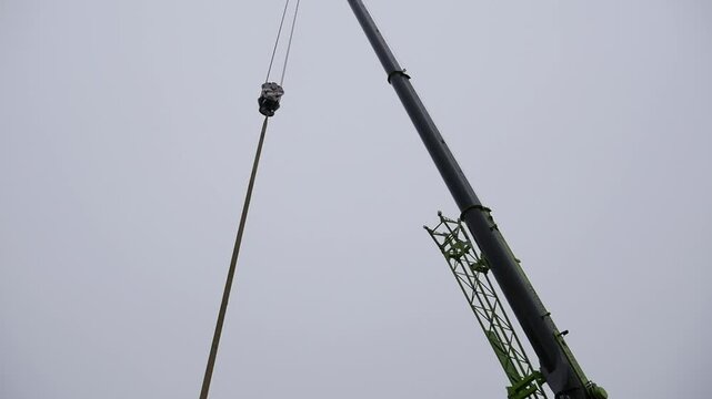 Construction crane holds suction cup for installing windows.