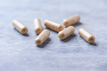 Korean Ginseng capsules. Concept for a healthy dietary supplementation. Wooden background. Soft focus. Close up.	
