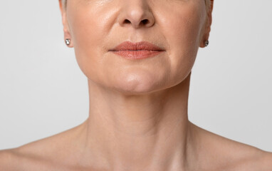 Anti-Aging Skincare. Cropped portrait of middle-aged woman with beautiful skin, light background,...