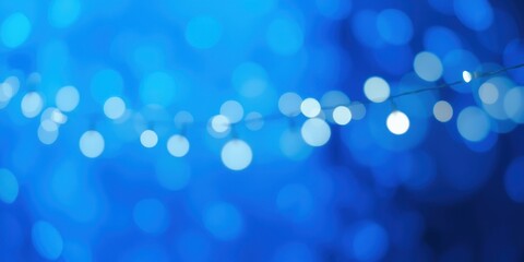 Obraz premium A String of Delicate White Lights Creates a Festive Atmosphere Against a Vibrant Blue Background