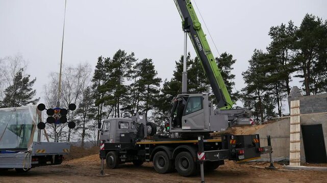 A crane installs windows at a construction site.