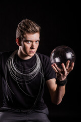 Man holding glass sphere with artistic wire design