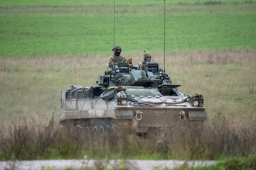 commander and gunner directing a British army Warrior FV510 IFV in action on a military exercise